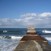 Surfers on each side of groyne, Gillis