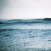 Paddling to the peak on the huge swell on Boca da Barra