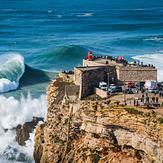 Big waves crashing near the Fort of Nazare Lighthouse in Nazare, Portugal.